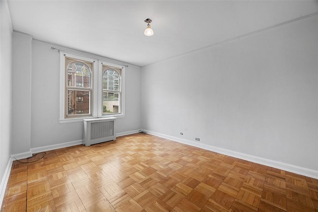 unfurnished room with baseboards and radiator