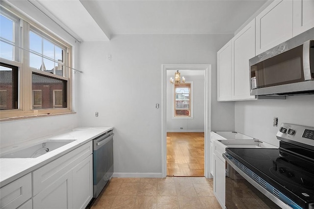 kitchen featuring plenty of natural light, a sink, white cabinetry, and appliances with stainless steel finishes