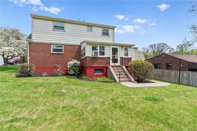 back of property with brick siding, fence, a yard, and cooling unit
