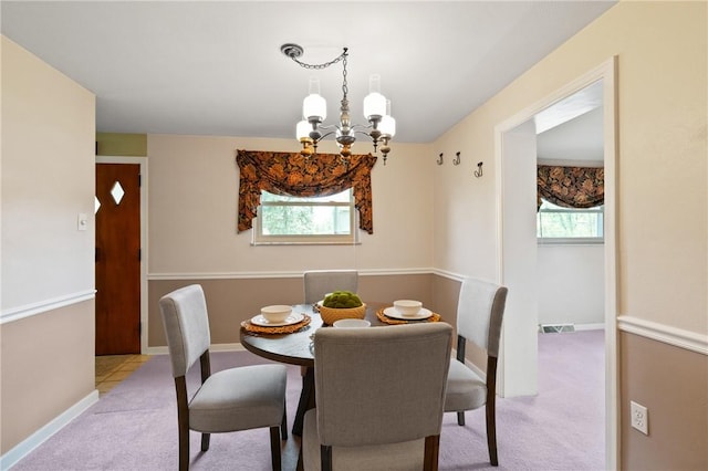 dining area with a wealth of natural light, carpet, visible vents, and a notable chandelier