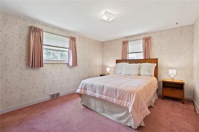 bedroom with visible vents and carpet
