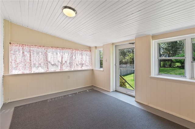unfurnished sunroom featuring wood walls and lofted ceiling