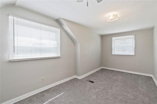 additional living space with carpet flooring, baseboards, visible vents, and lofted ceiling