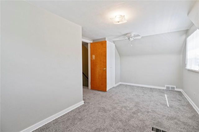 bonus room with carpet flooring, a ceiling fan, baseboards, vaulted ceiling, and visible vents