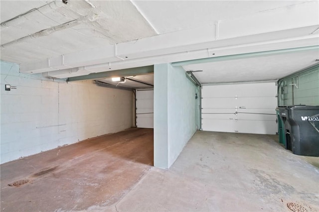 garage featuring a garage door opener and concrete block wall
