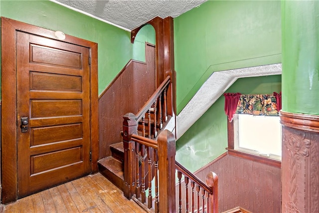 503 Beechwood Ave, Carnegie, PA 15106 - staircase featuring wood-type flooring, a textured ceiling, and a wainscoted wall