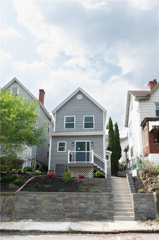 view of front of property with stairs and cooling unit