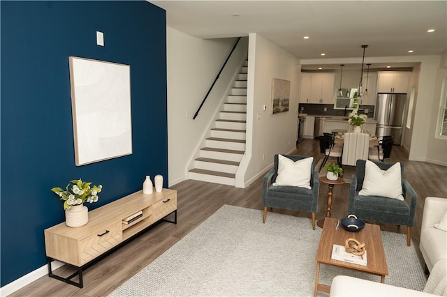 living area with baseboards, recessed lighting, dark wood finished floors, and stairway