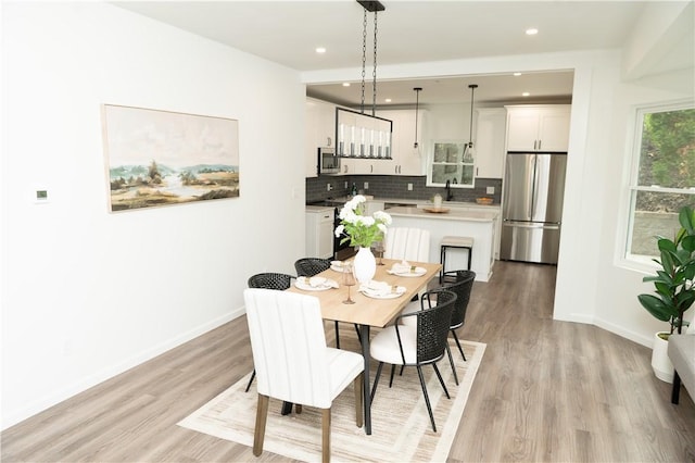 dining space with baseboards, recessed lighting, and light wood-style flooring