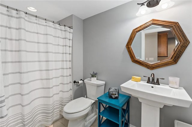 bathroom with a sink, a shower with shower curtain, tile patterned floors, and toilet