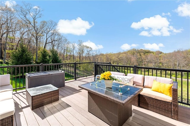 deck featuring outdoor lounge area and a forest view