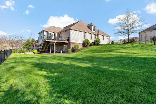 rear view of property with a fenced backyard, a yard, stairway, and a deck