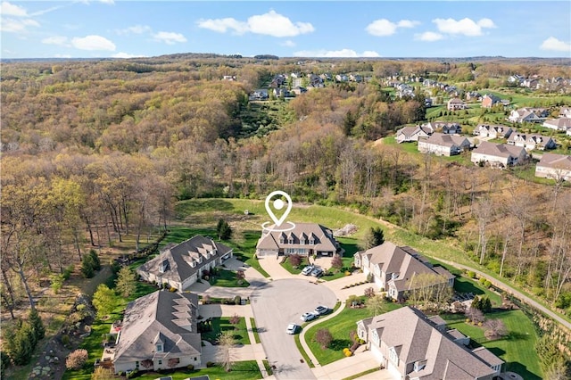 aerial view featuring a forest view and a residential view