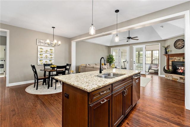 kitchen featuring dark wood-style flooring, a sink, dishwasher, decorative light fixtures, and open floor plan