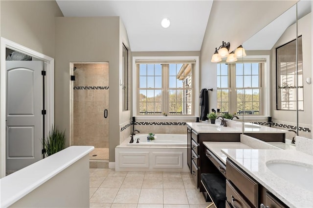 full bathroom featuring a garden tub, a sink, two vanities, and a shower stall