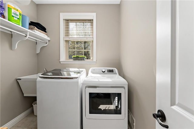 laundry room with laundry area, tile patterned flooring, baseboards, and washing machine and dryer