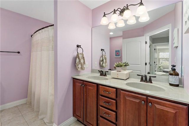 bathroom with double vanity, a sink, tile patterned flooring, and an inviting chandelier