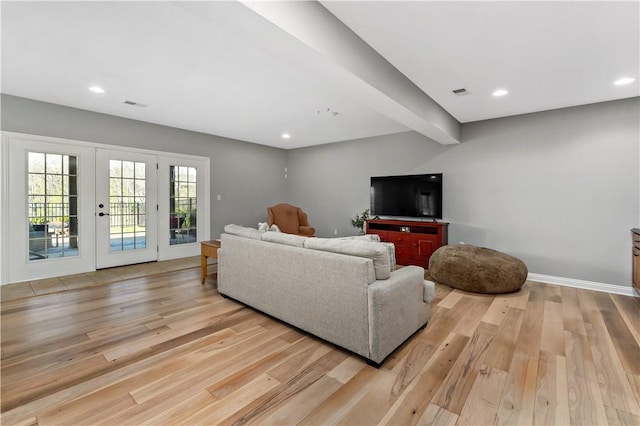 living area with light wood-type flooring, recessed lighting, visible vents, and french doors