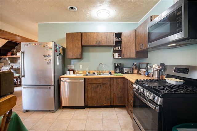 357 Pohls Rd, Raccoon Twp, PA 15001 - kitchen featuring a textured ceiling, appliances with stainless steel finishes, open shelves, a sink, and light countertops