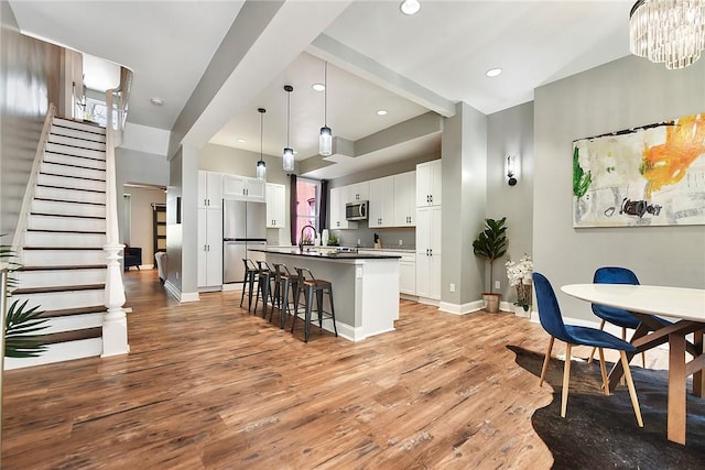 308 Jacksonia St, Central North Side, PA 15212 - kitchen with a kitchen breakfast bar, appliances with stainless steel finishes, a center island with sink, light wood-type flooring, and white cabinets