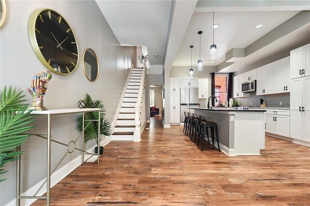 308 Jacksonia St, Central North Side, PA 15212 - kitchen featuring white cabinets, stainless steel appliances, a kitchen breakfast bar, and light wood-type flooring