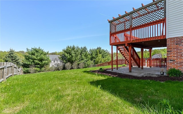 view of yard featuring a patio area, fence, and a wooden deck