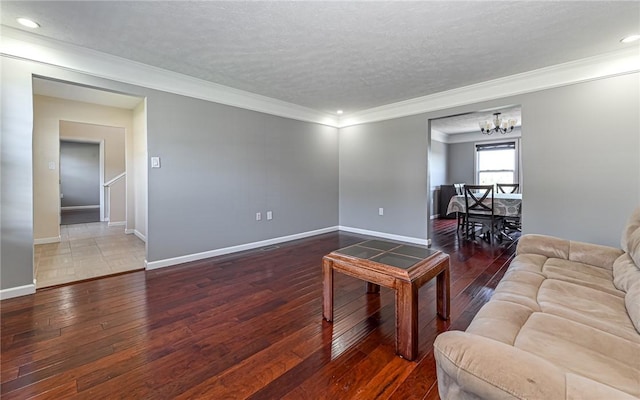 living area with crown molding, hardwood / wood-style floors, recessed lighting, a textured ceiling, and a chandelier
