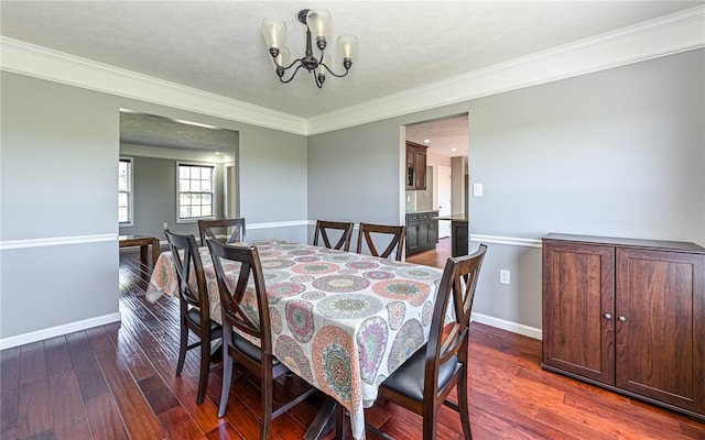 dining space with baseboards, a notable chandelier, ornamental molding, and hardwood / wood-style flooring