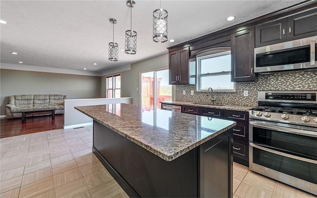 kitchen with a sink, a center island, dark stone counters, stainless steel appliances, and tasteful backsplash