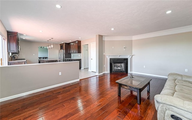 living area with crown molding, recessed lighting, baseboards, and hardwood / wood-style floors