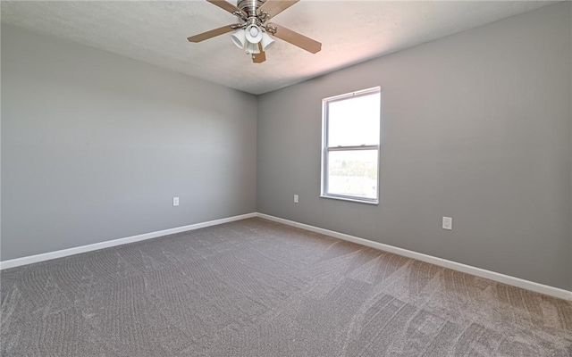 carpeted empty room featuring baseboards and a ceiling fan