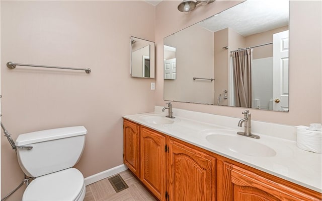 full bathroom featuring double vanity, toilet, visible vents, and a sink