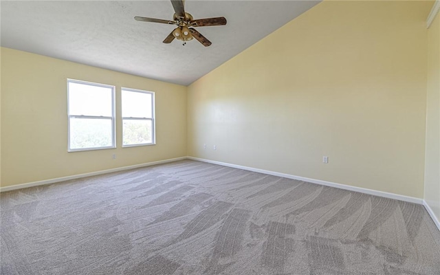 empty room featuring carpet floors, a ceiling fan, baseboards, and vaulted ceiling