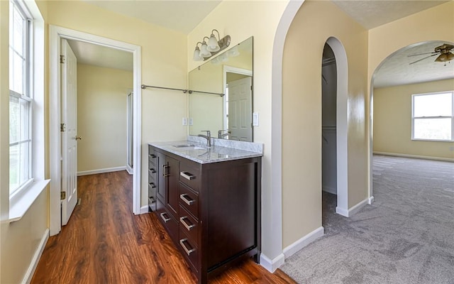 bathroom featuring wood finished floors, baseboards, ceiling fan, and vanity