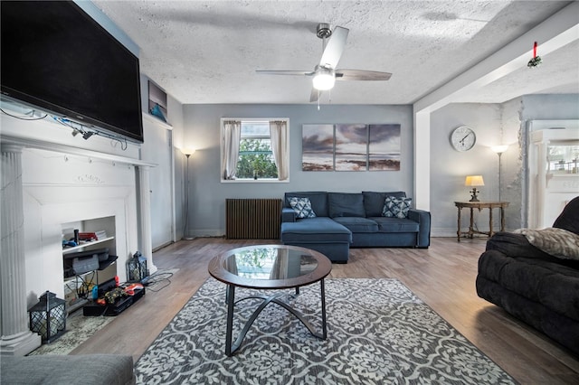206 7th St, Oakmont, PA 15139 - living area featuring radiator, a textured ceiling, ceiling fan, wood finished floors, and baseboards