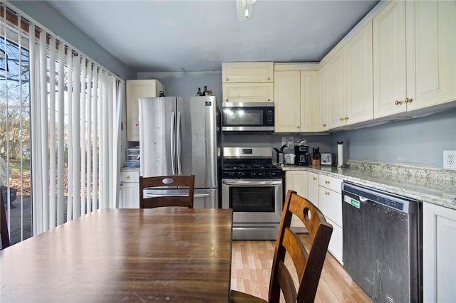 206 7th St, Oakmont, PA 15139 - kitchen featuring stainless steel appliances, light wood-style floors, and light stone counters