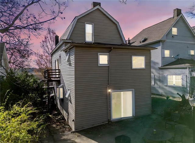206 7th St, Oakmont, PA 15139 - back of house at dusk featuring a chimney and a gambrel roof