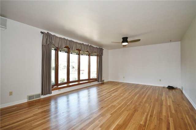 spare room with visible vents, a ceiling fan, baseboards, and light wood-type flooring