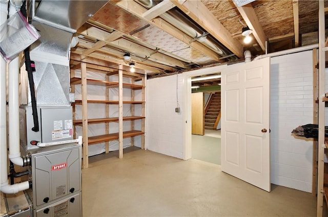 unfinished below grade area featuring heating unit and stairs