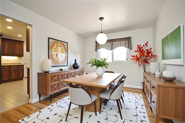 dining space featuring recessed lighting, baseboards, and light wood finished floors