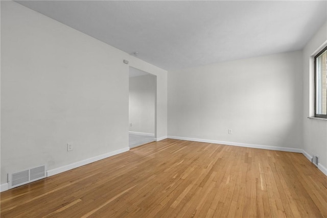 empty room featuring baseboards, visible vents, and light wood-style flooring