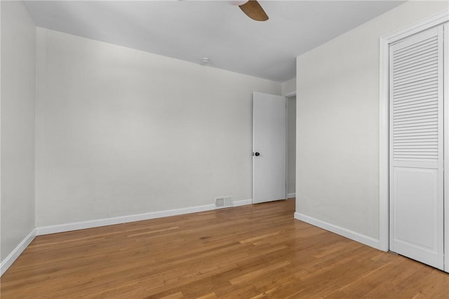 unfurnished bedroom with ceiling fan, visible vents, baseboards, a closet, and light wood-style flooring