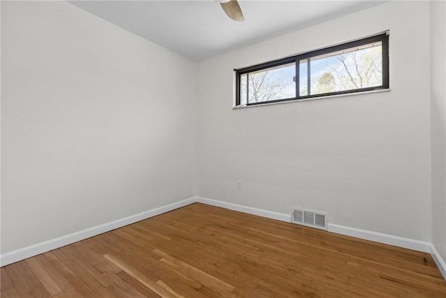 unfurnished room featuring visible vents, baseboards, ceiling fan, and wood finished floors
