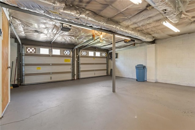 garage with concrete block wall and a garage door opener