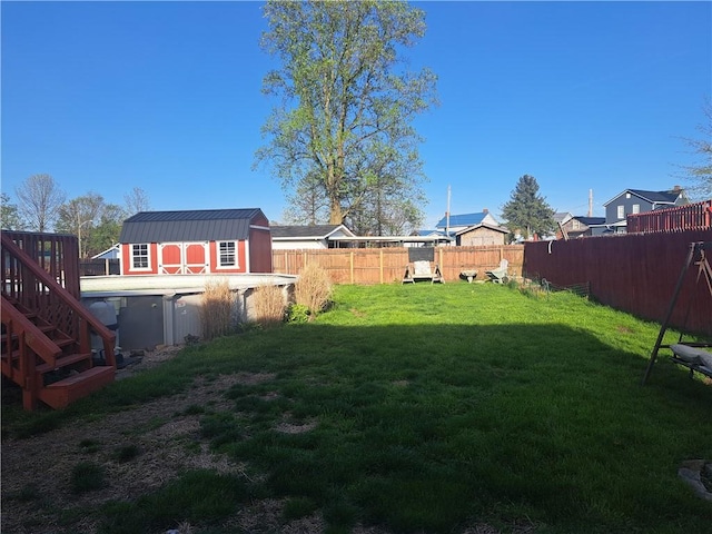 view of yard featuring a storage unit, an outdoor structure, and fence