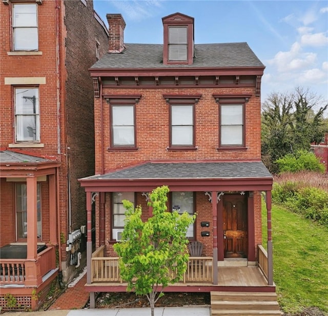 view of front of property with brick siding, a shingled roof, and a chimney