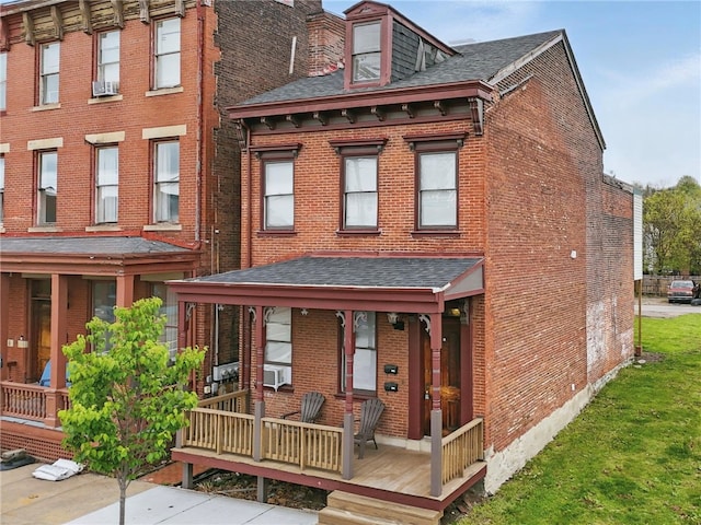 view of front of house with covered porch, brick siding, and a shingled roof