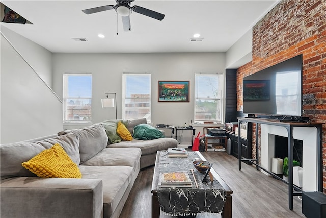 living room featuring ceiling fan, plenty of natural light, wood finished floors, and visible vents