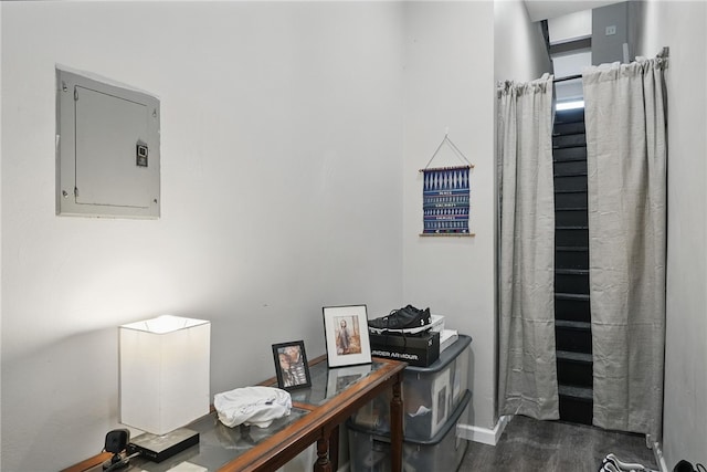 home office with baseboards, wood finished floors, and electric panel