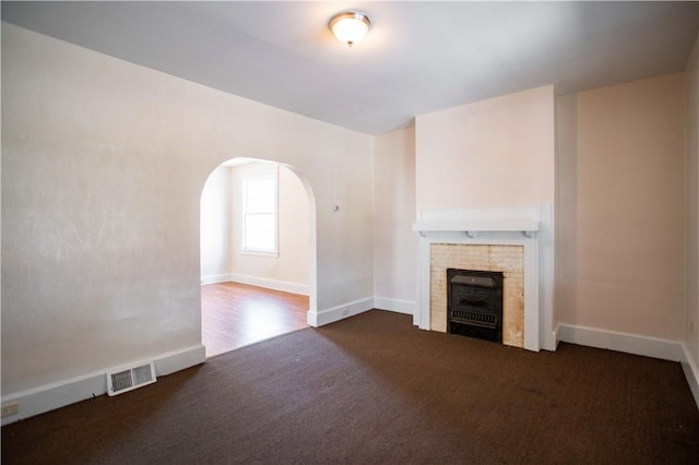 1315 Main St, Aliquippa, PA 15001 - unfurnished living room with visible vents, a fireplace, baseboards, arched walkways, and carpet flooring